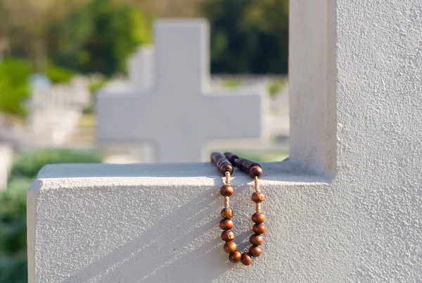 Old rosary on cemetery cross — Stock Photo, Image