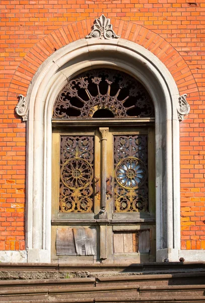 Ancient grungy doors in a brick wall — Stock Photo, Image