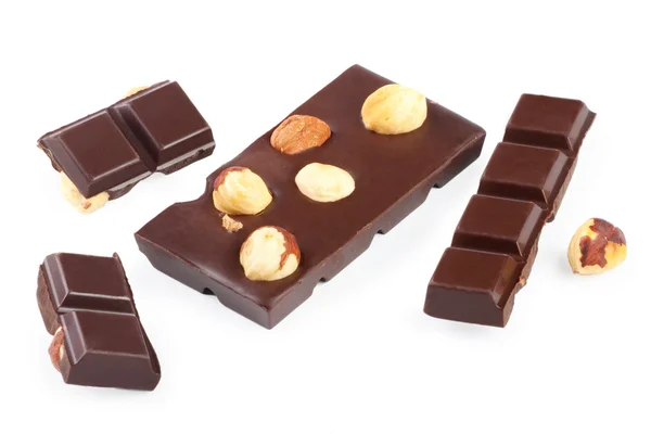 Stukken van chocolade bar met noten op witte achtergrond — Stockfoto