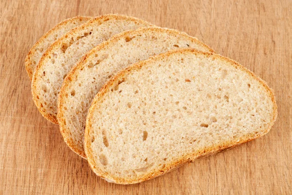Plastry świeżego chleba na pokładzie cięcia drewna — Zdjęcie stockowe