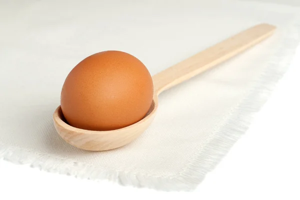 Коричневое яйцо в деревянной ложке — стоковое фото