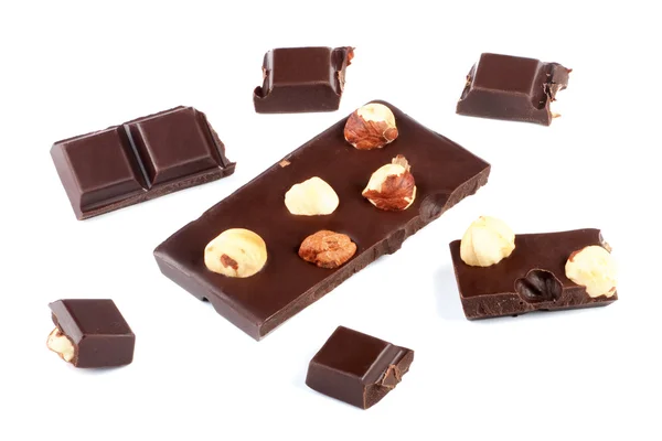 Stukken van melk chocolade bar met noten geïsoleerd op wit — Stockfoto