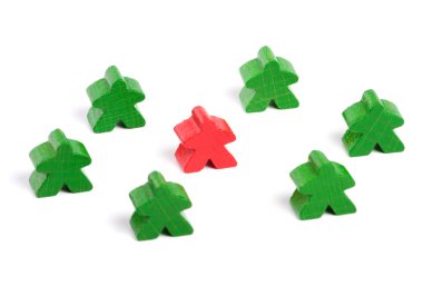 Red wooden figure among green ones on white background clipart