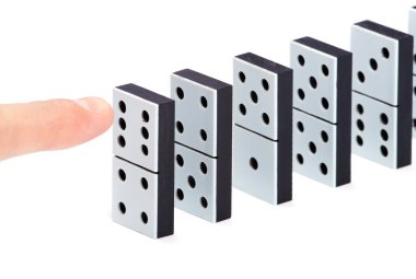 Finger ready to push domino pieces to cause chain reaction clipart