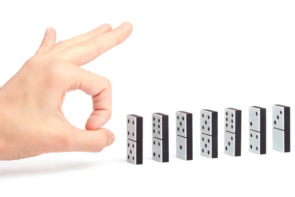 Tangan siap untuk mendorong domino dalam garis untuk menyebabkan reaksi berantai — Stok Foto