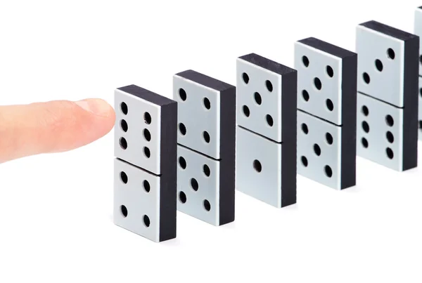 Finger ready to push domino pieces to cause chain reaction — Stock Photo, Image
