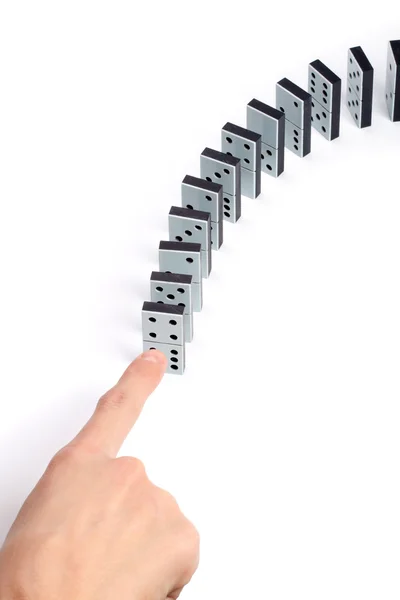 Mão empurrando linha de peças de dominó — Fotografia de Stock