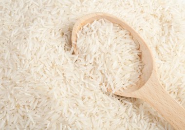 Uncooked basmati rice in a wooden spoon clipart