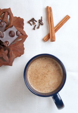 Cup of hot cacao with a chocolate bar, cinnamon and cloves clipart