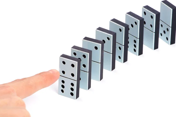 Mão pronta para empurrar peças de dominó para causar reação em cadeia — Fotografia de Stock