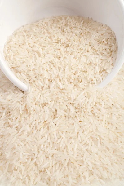 Неварений рис басматі в керамічній мисці на білому тлі — стокове фото