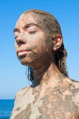 Young beautiful woman getting a body mud therapy clipart