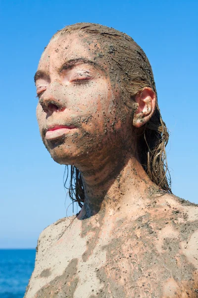 Young beautiful woman getting a body mud therapy — Stock Photo, Image