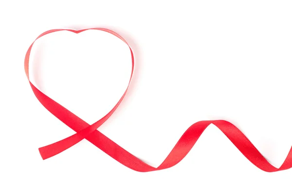 Rött band hoprullade i hjärta form isolerad på vit bakgrund — Stockfoto