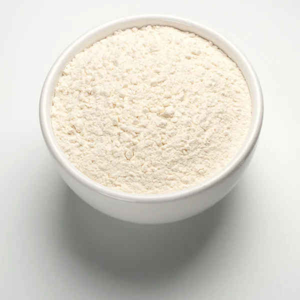 Farinha de trigo em uma placa no fundo branco — Fotografia de Stock