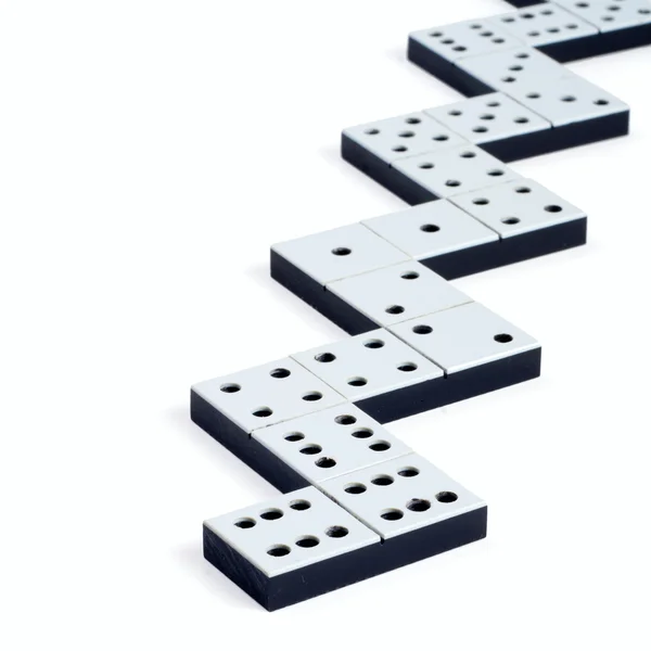 Dominobrikker i en linje eller sikksakk på hvit bakgrunn – stockfoto