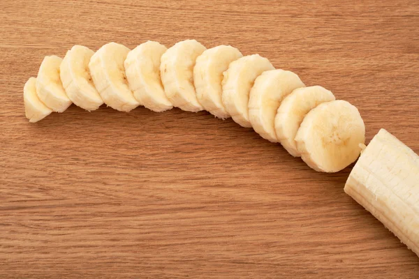 Plátanos en rodajas sobre un fondo de madera — Foto de Stock