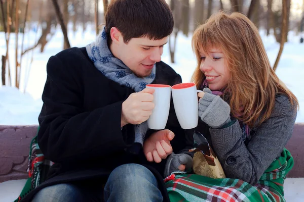 Jonge geliefde paar opwarming van de aarde zelf in de winter park — Stockfoto