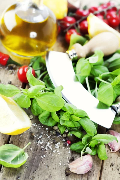 切割板与 Mezzaluna 橄榄油和蔬菜上的新鲜 切碎草药 — 图库照片