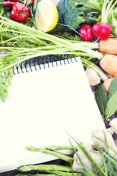 Open notebook and fresh vegetables — Stock Photo, Image