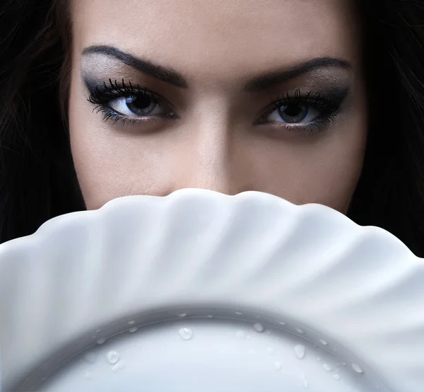 グラマー女性の手に白い磁器の皿 — ストック写真