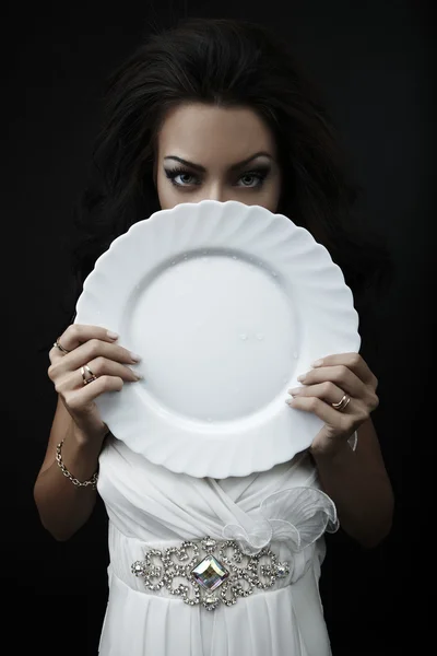 Mujer glamour con una placa de porcelana blanca en las manos — Foto de Stock