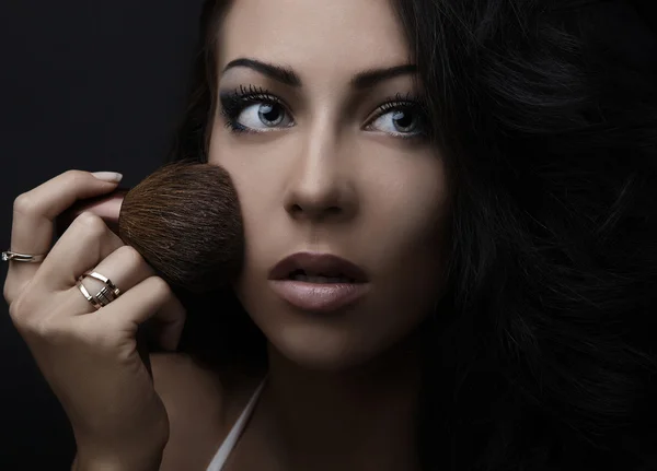 Retrato de atractiva mujer adulta joven aplicando colorete — Foto de Stock