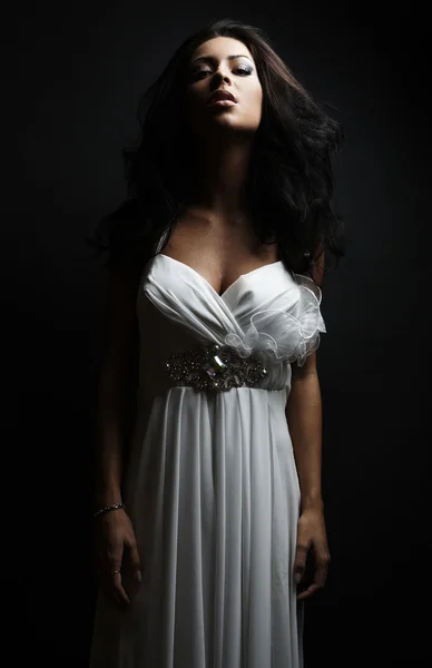Hermosa mujer vistiendo vestido blanco sobre una pared grumosa —  Fotos de Stock