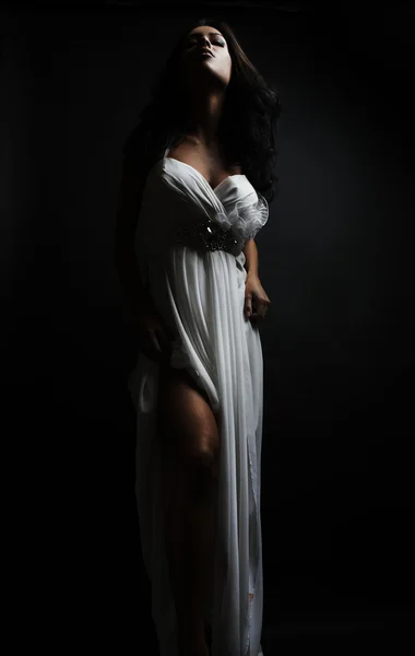 Krásná žena nosí bílé šaty přes výstřední zeď — Stock fotografie