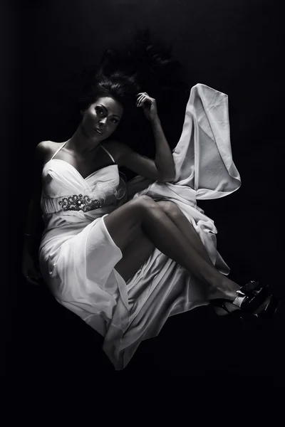 Mooie vrouw dragen witte jurk over een grungy muur — Stockfoto