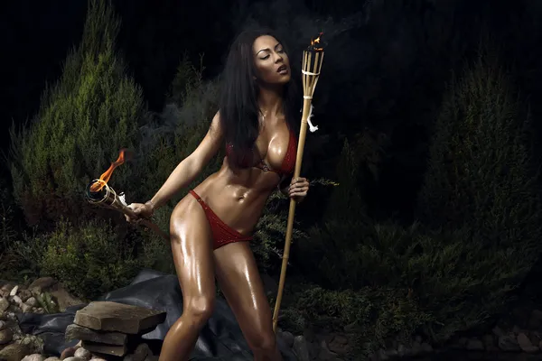 Beautiful healthy fit woman wearing red bikini & Holding burning torche — Stock Photo, Image