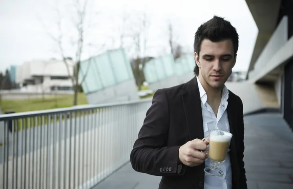 コーヒーを飲む若い魅力的なビジネスマンの肖像画 — ストック写真