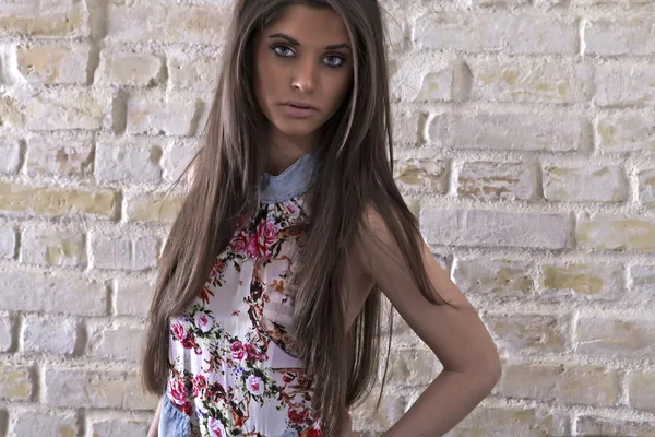 レンガ壁の背景上の若いセクシーな女性 — ストック写真