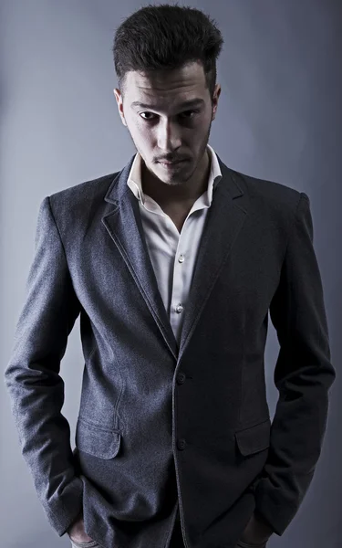 灰色の背景上のスーツを着た若い魅力的な男 — ストック写真