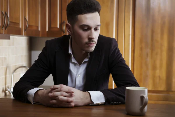 Man sitting at the kitchen counter — Stock Photo, Image