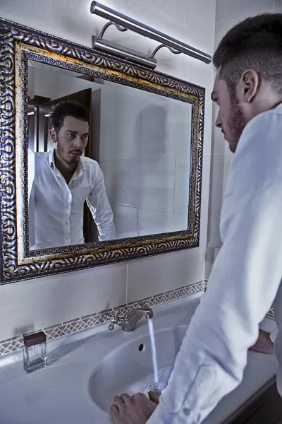 Człowiek ma pewien patrzeć na siebie w lustrze. — Zdjęcie stockowe
