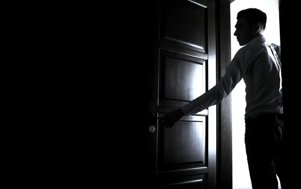 Hombre entrando en una habitación oscura — Foto de Stock