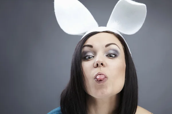 Funny Brunette in a bright sweater with rabbit ears on her head. — Stock Photo, Image