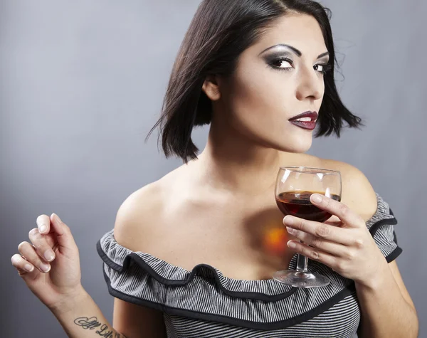 Студійний портрет красивої брюнетки, що тримає скляне вино . — стокове фото