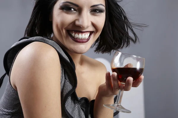 Studio portrait of beautiful brunette holding a glass wine. — Stock Photo, Image