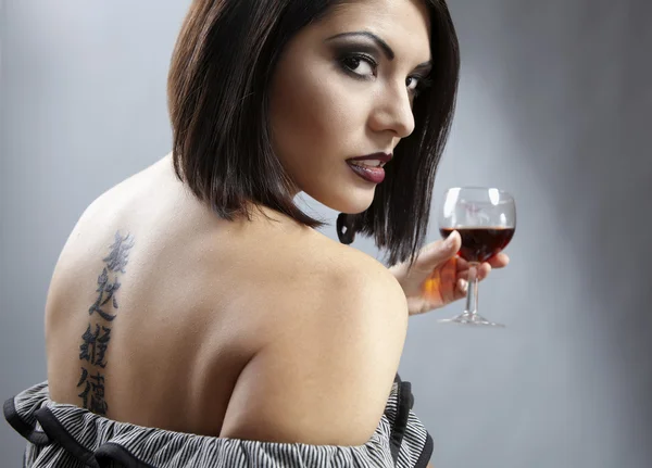 Студийный портрет красивой брюнетки с бокалом вина . — стоковое фото