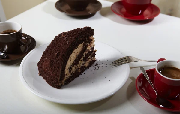 Chocolate cake on the white plate with a cup of coffee — Stock Photo, Image