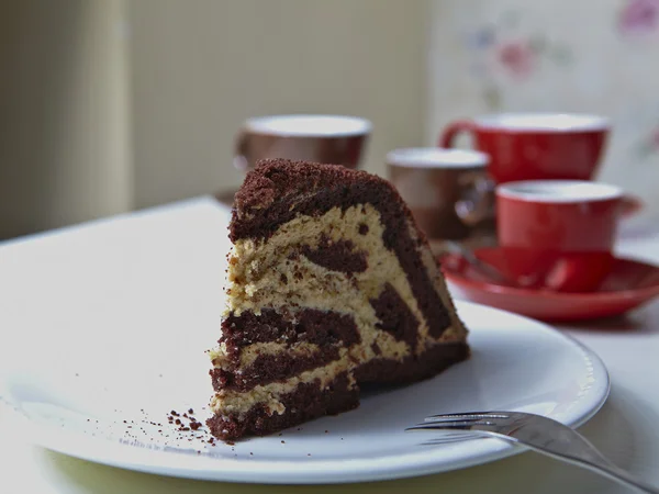 Chocolade taart op de witte plaat met een kopje koffie — Stockfoto