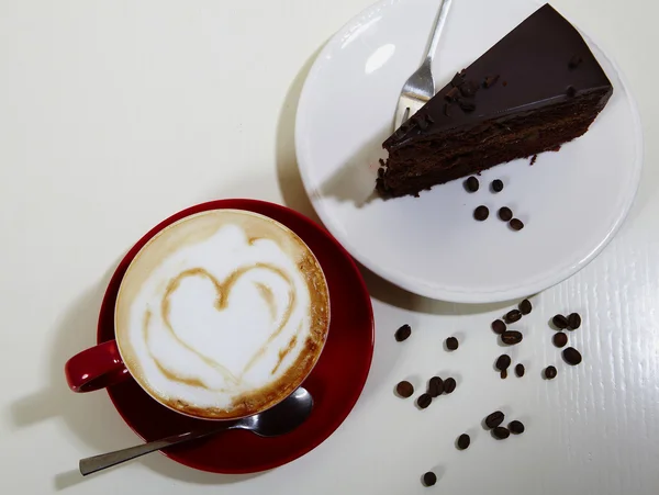 Pastel de chocolate en el plato blanco con una taza de café — Foto de Stock