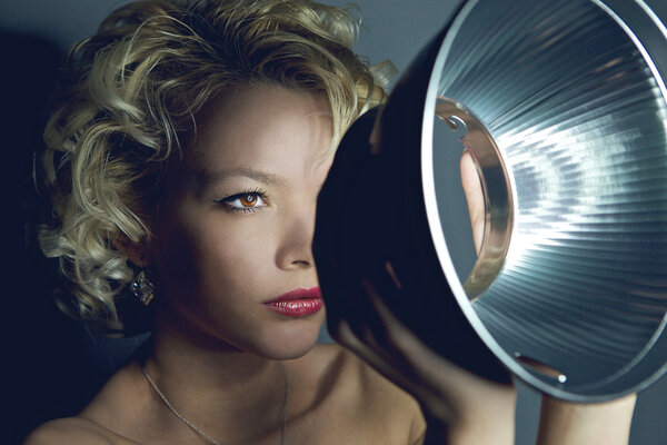 Stylish close-up portrait of young girl observing through metal object.