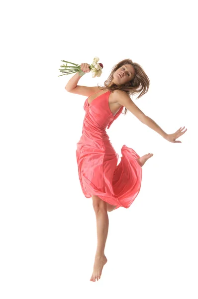 Kobieta w skok z kwiatami w ręce — Zdjęcie stockowe