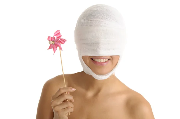 Młoda kobieta z głową bandażowane w sposób z zabawkami — Zdjęcie stockowe