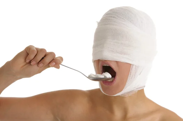 Ung kvinna med bandagerade huvud accepterar medicin — Stockfoto