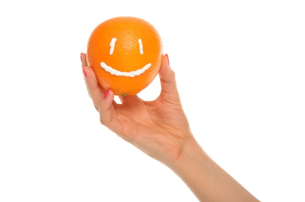 Mano sostiene naranja con sonrisa dibujada —  Fotos de Stock