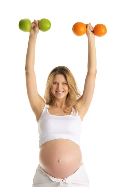 リンゴとオレンジから作られたフィットネス ダンベルに関与する妊娠中の女性 — ストック写真